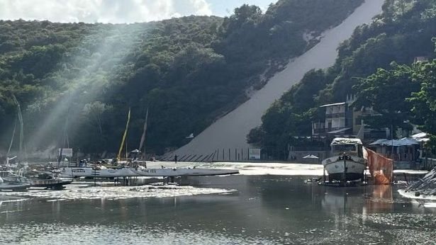 Maré alta alaga faixa de areia em Ponta Negra e derruba cerca no Morro do Careca